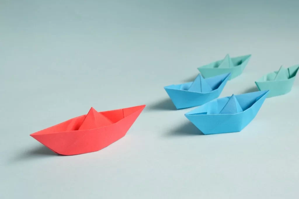 pexels-photo-194094 Colorful origami paper boats arranged to depict leadership and teamwork concepts.